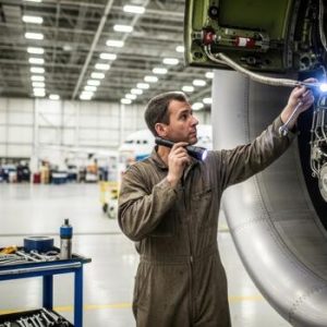a-man-in-a-work-uniform-is-working-on-an-airplane-engine-photo